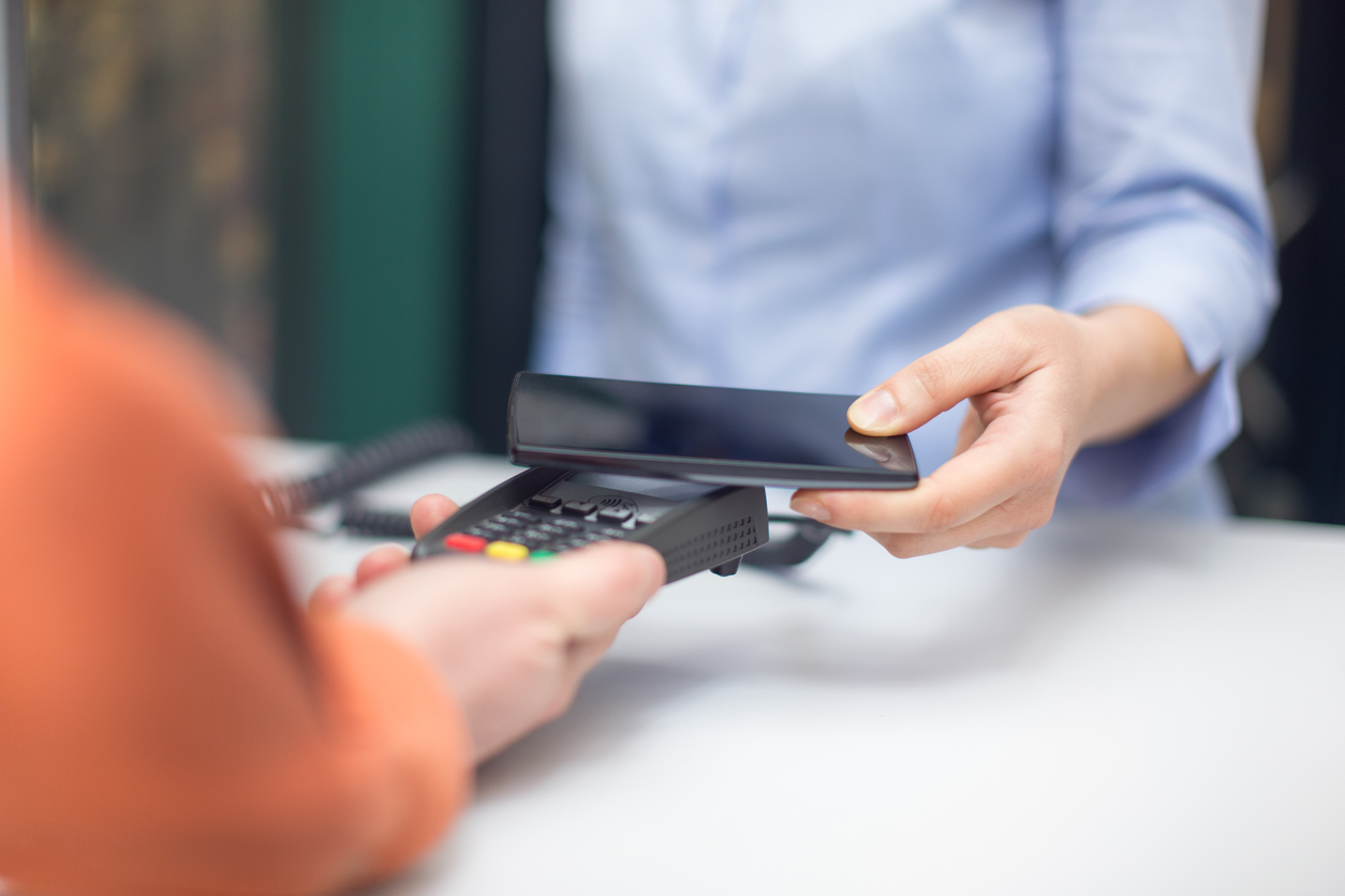 Person using smartphone to pay on eftpos machine